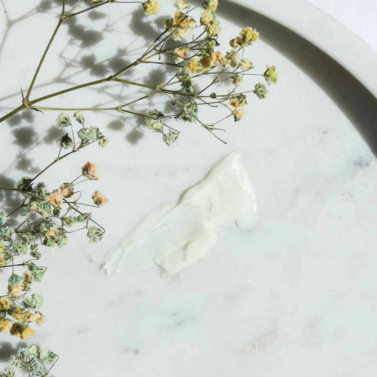 La crema CBD è stata spalmata su un tavolo e sopra di essa è stato posto un bouquet.