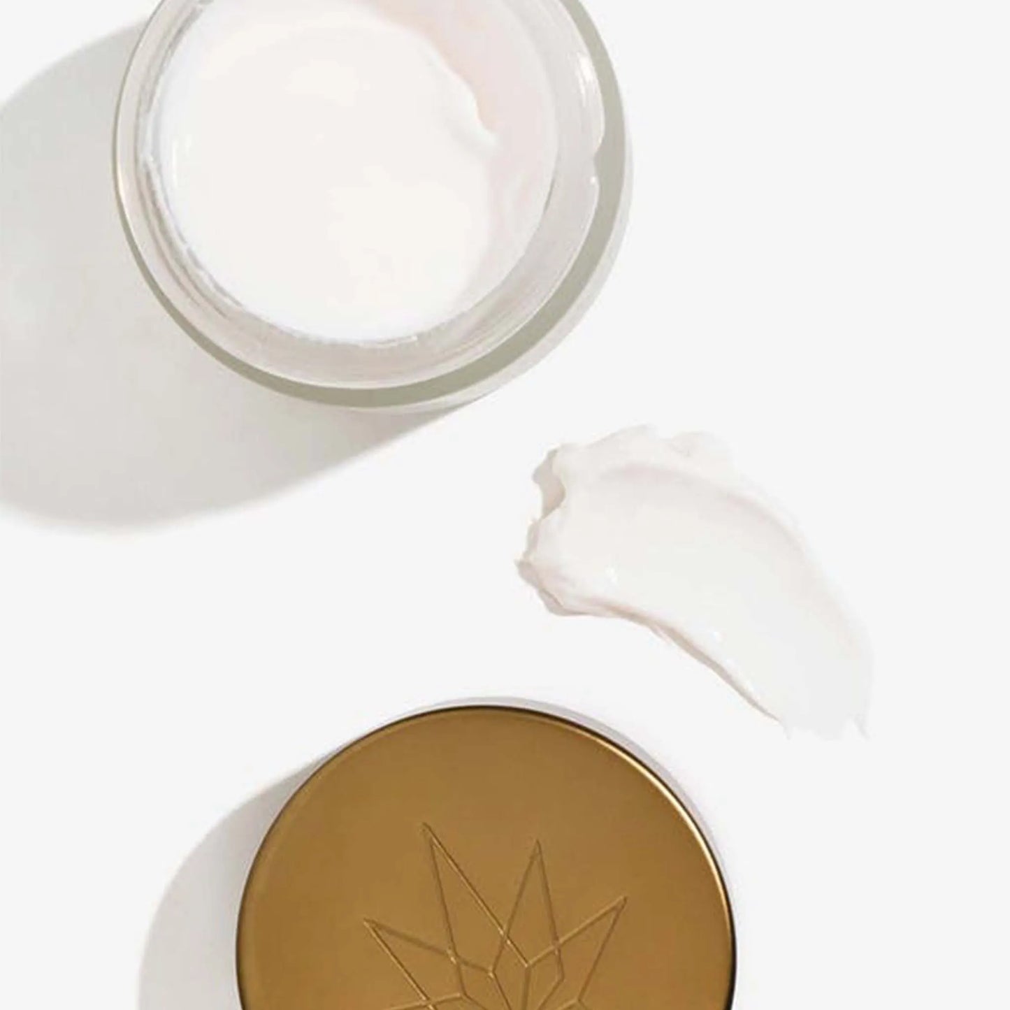 Una confezione aperta con accanto il coperchio della Crema Notte Viso - CBD & Vitamina E e una chiazza di crema pura.