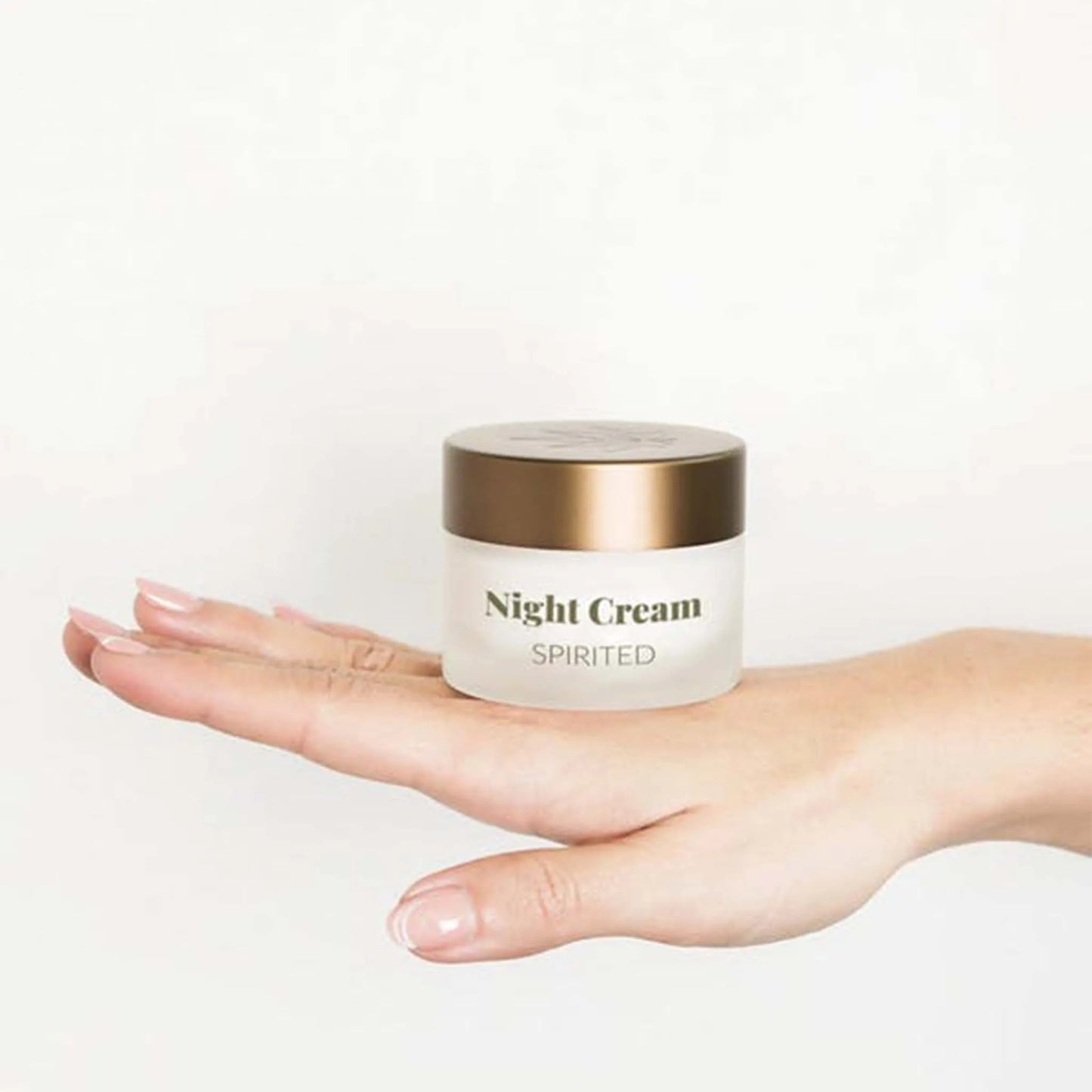 Sul dorso di una mano femminile si trova un barattolo di Crema Notte Viso - CBD & Vitamina E