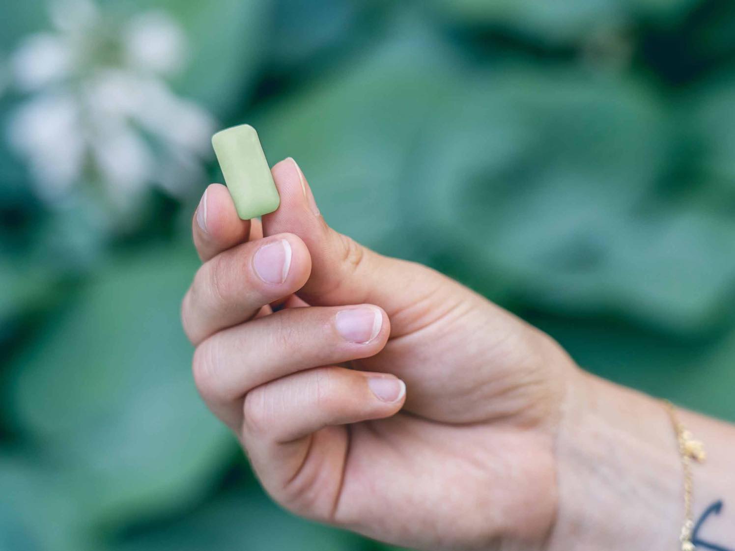 Una mano tiene un verde Chewing gum CBD