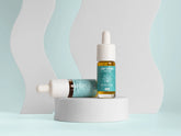 Due flaconi di olio CBD Nordic Oil con contagocce su piedistallo bianco