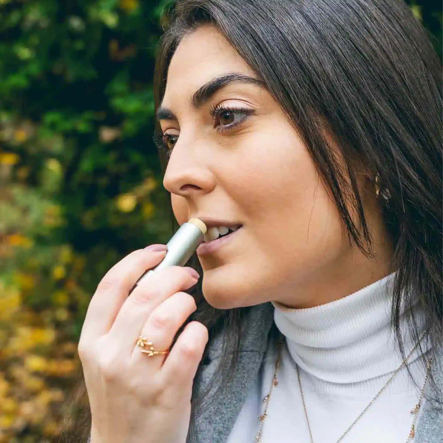 Una donna applica sulle labbra il balsamo per labbra CBD.
