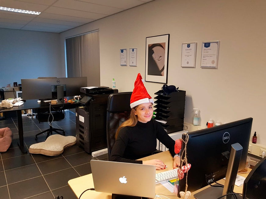 Una donna in un ufficio che indossa un cappello da Babbo Natale