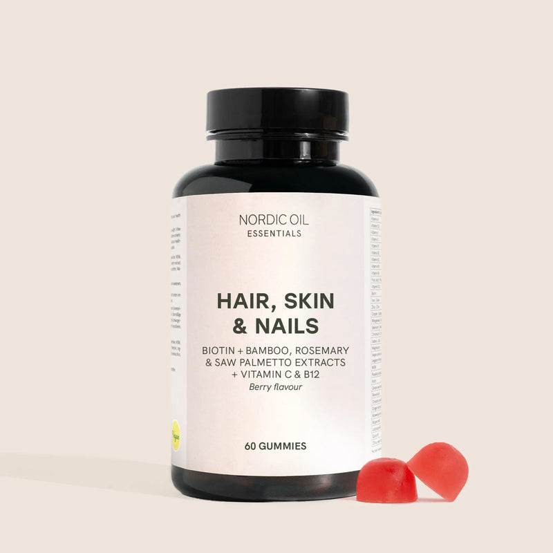 Bottiglia di integratori Nordic Oil Essentials Hair, Skin & Nails con due gummies rosse accanto (60 pezzi, gusto berry)